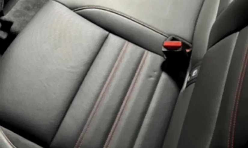 Siège en cuir noir à surpiqûres rouges après nettoyage intérieur